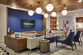 A lobby with couches chairs and tables and a television